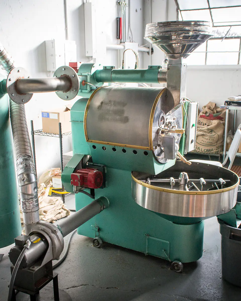 A vintage drum coffee roaster in a working roastery
