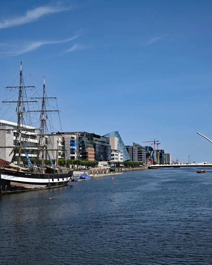 The River Liffey in Dublin's Docklands with a tall ship moored