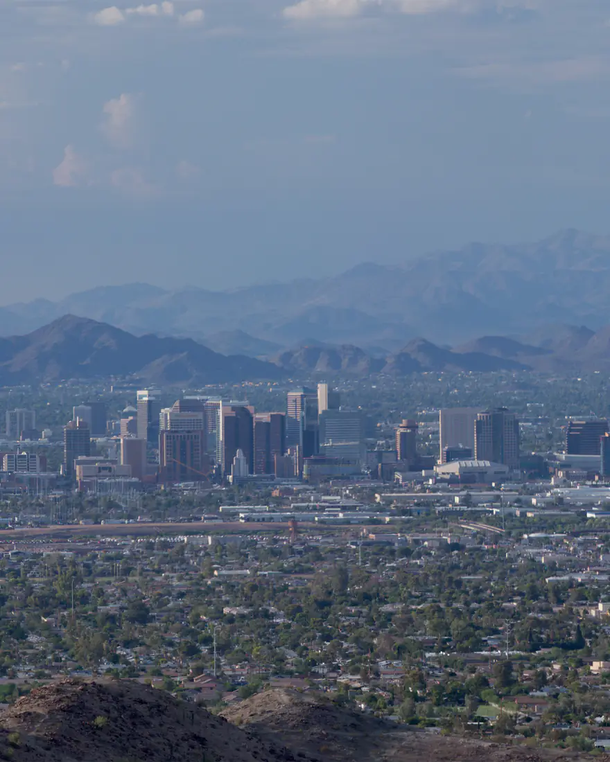 Downtown Phoenix skyline across the valley with desert mountains behind