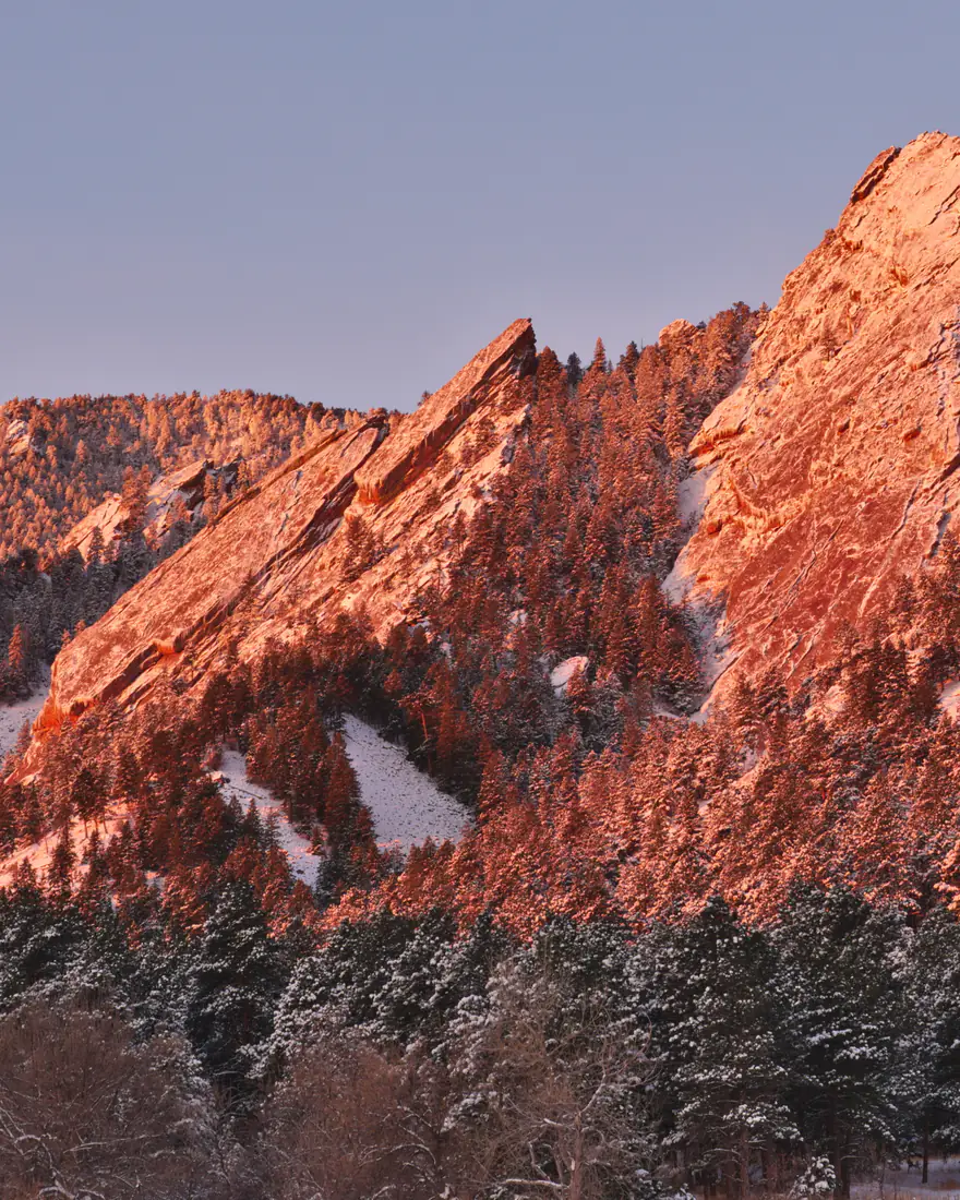 The Flatirons glowing at sunrise above Boulder