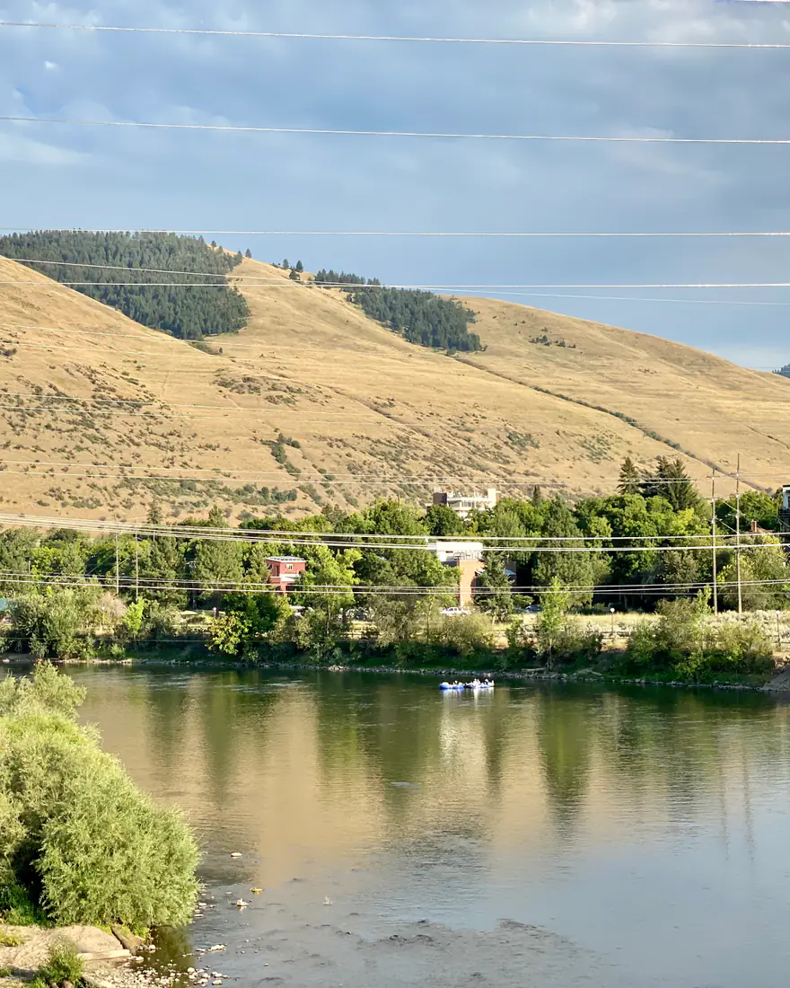The Clark Fork River in Missoula below grassy hills