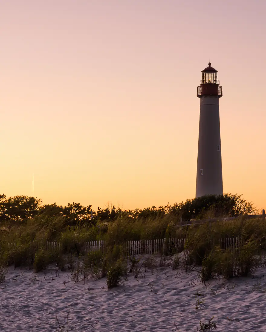 The Cape May Lighthouse above the dunes at sunset