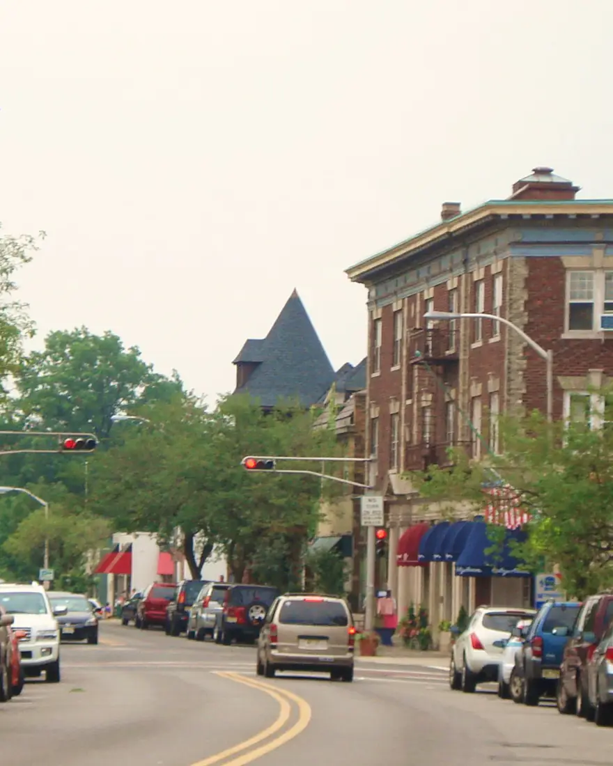 Brick storefronts and flags along a downtown street in Upper Montclair, New Jersey