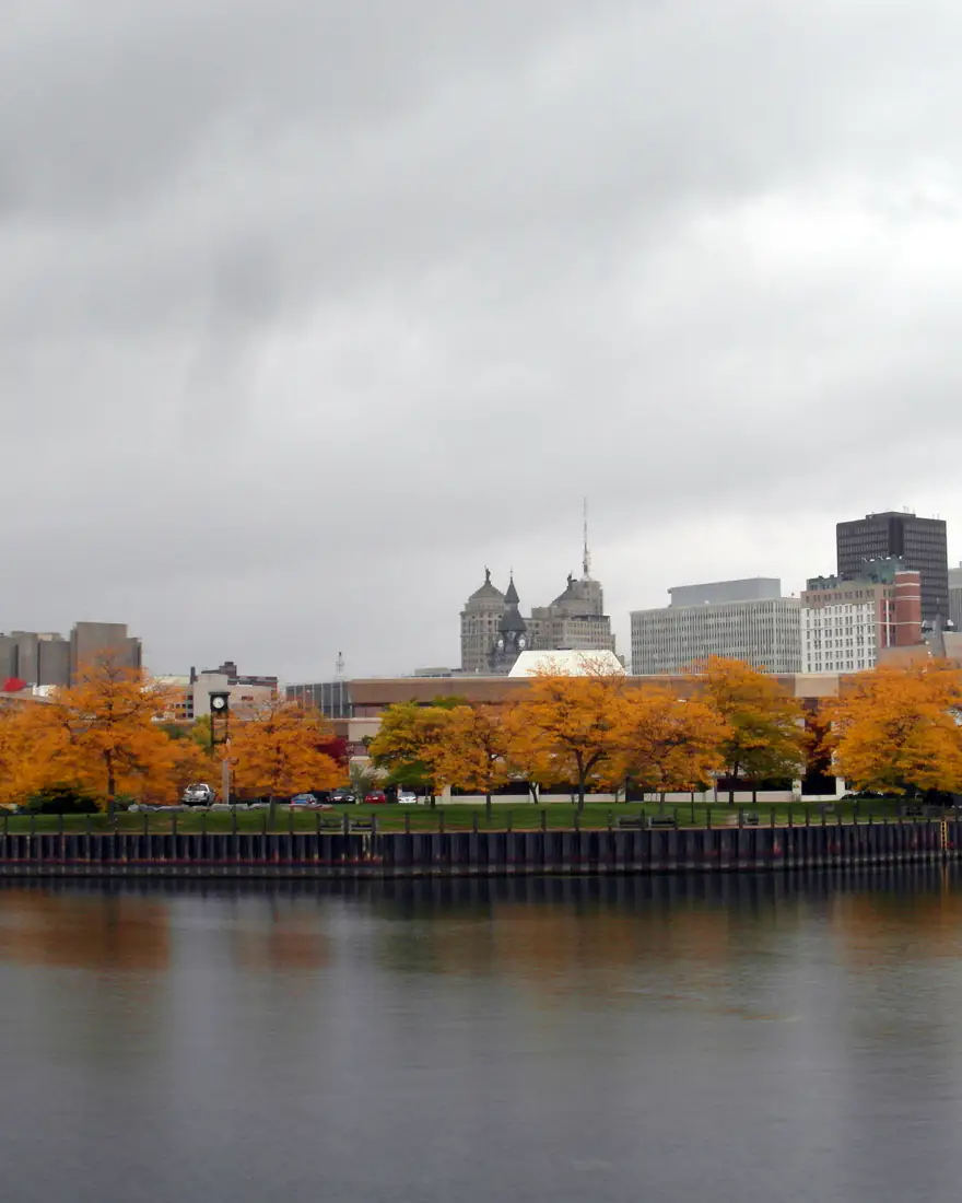 Buffalo's skyline and City Hall above autumn trees at Erie Basin Marina