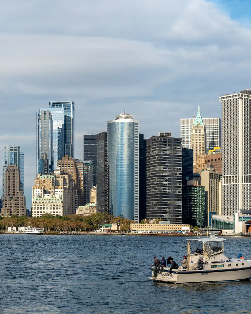 Lower Manhattan's skyline from Governors Island, with a fishing boat in the harbor