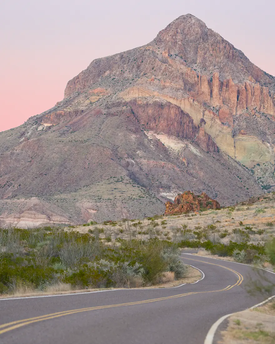 A road winding toward the mountains at sunset in Big Bend National Park